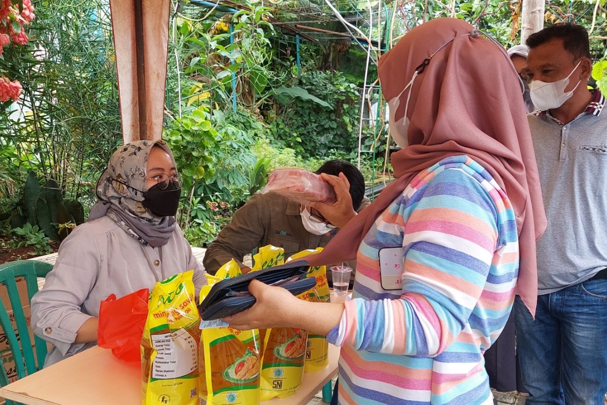 Warga saat membeli minyak goreng dan daging kerbau di Posko RT04/RW11, Kelurahan Tanah Tinggi, Kecamatan Tangerang, Kota Tangerang, Jumat (4/3/2022).