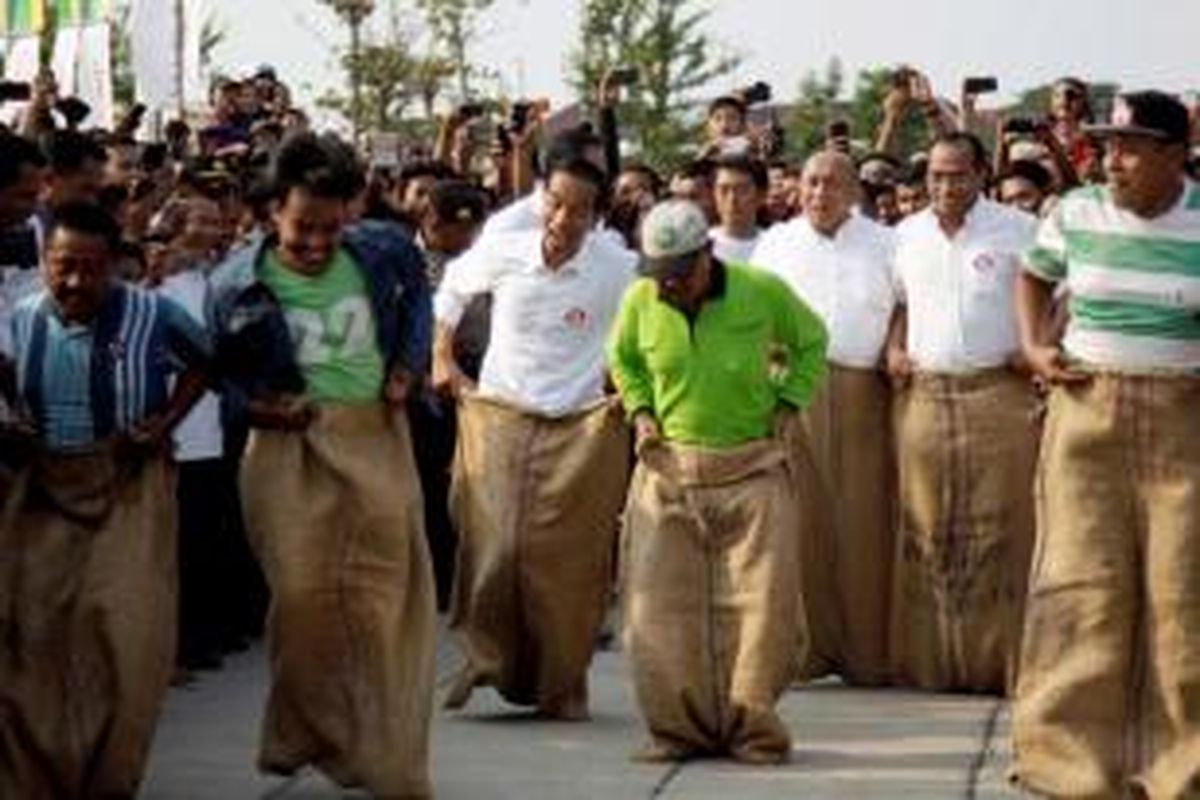 Gubernur DKI Jakarta dan juga Calon Presiden terpilih Joko Widodo (tiga kiri) alias Jokowi, turut serta dalam lomba balap karung di acara Pesta Rakyat Waduk Pluit, di Taman Waduk Pluit, Jakarta Utara, Minggu (17/8/2014). Selain ikut lomba balap karung, Jokowi juga menyempatkan bermain bola bersama sejumlah selebriti. 