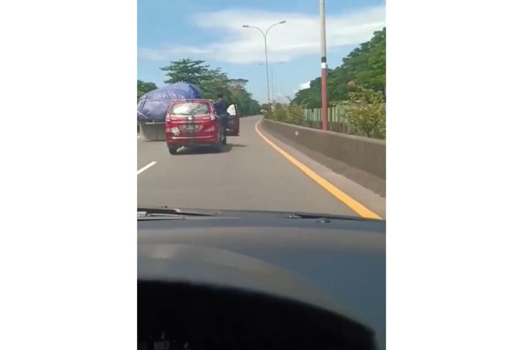 Tangkapan layar video viral pengemudi kendarai mobilnya sambil berdiri di jalan tol Makassar.