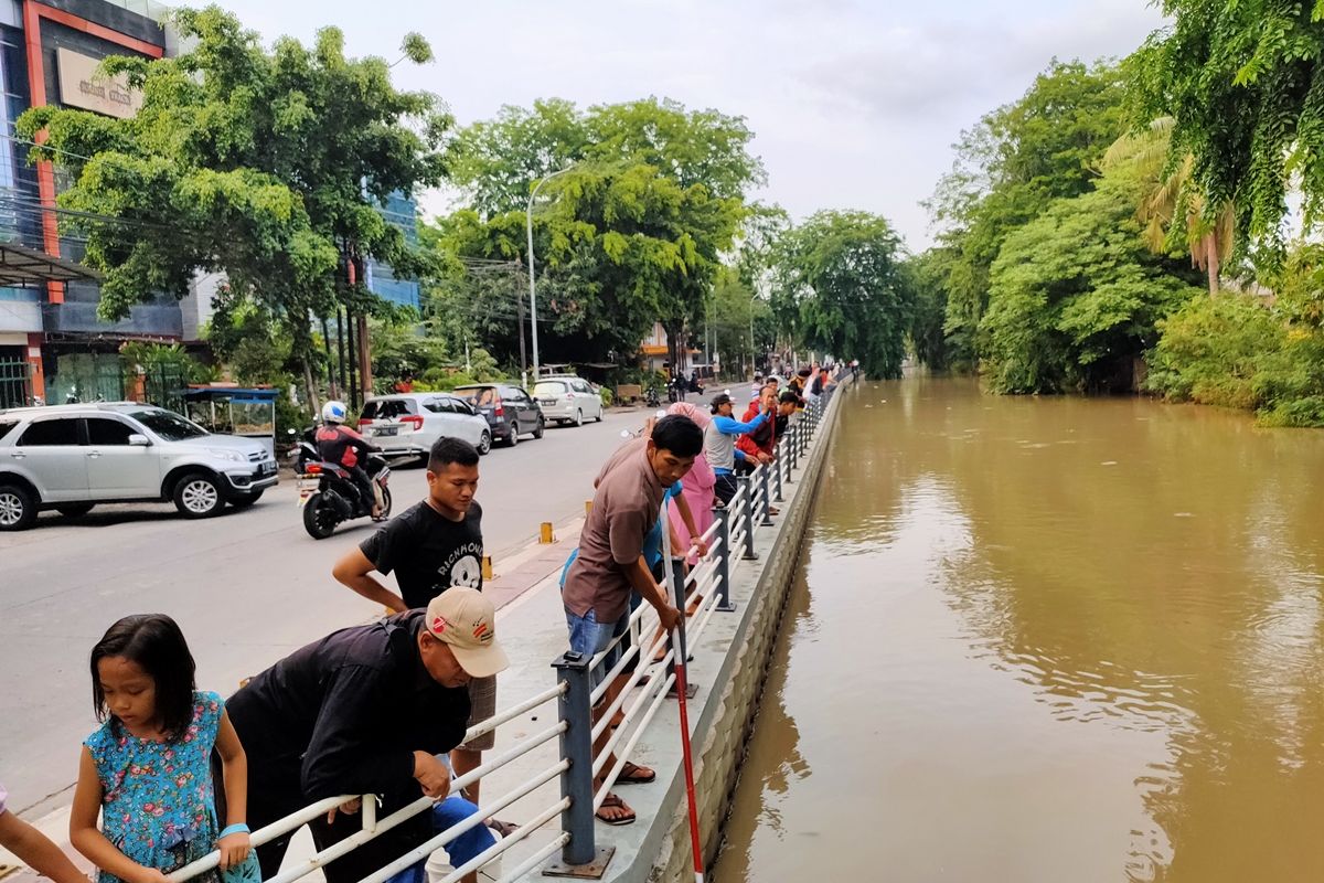 Sejumlah warga meraup ikan mabuk menggunakan serokan bambu di Saluran Irigasi Rawatembaga, Bekasi Selatan, Kamis (28/11/2019) sore.