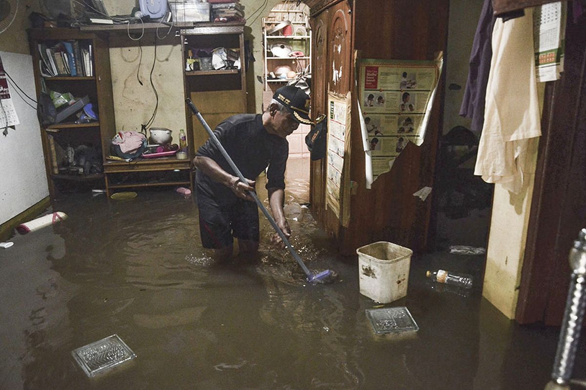 Warga beraktivitas di rumahnya saat banjir di kampung Buaran Jaya, Harapan Mulya yang terendam banjir di Bekasi, Jawa Barat, Selasa (21/1/2020). Menurut warga banjir memasuki rumah warga pada pukul 04.00 WIB setinggi 60-90 cm akibat curah hujan tinggi dan saluran drainase yang buruk.