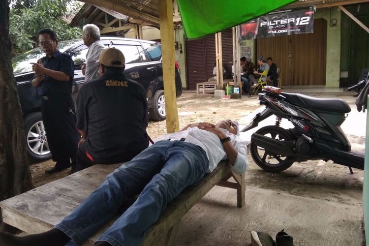 Dedi Mulyadi tertidur di bangku depan warung tegal di kawasan Perempatan Ciranggon, Kecamatan Majalaya, Kabupaten Karawang, Senin (19/2/2018).