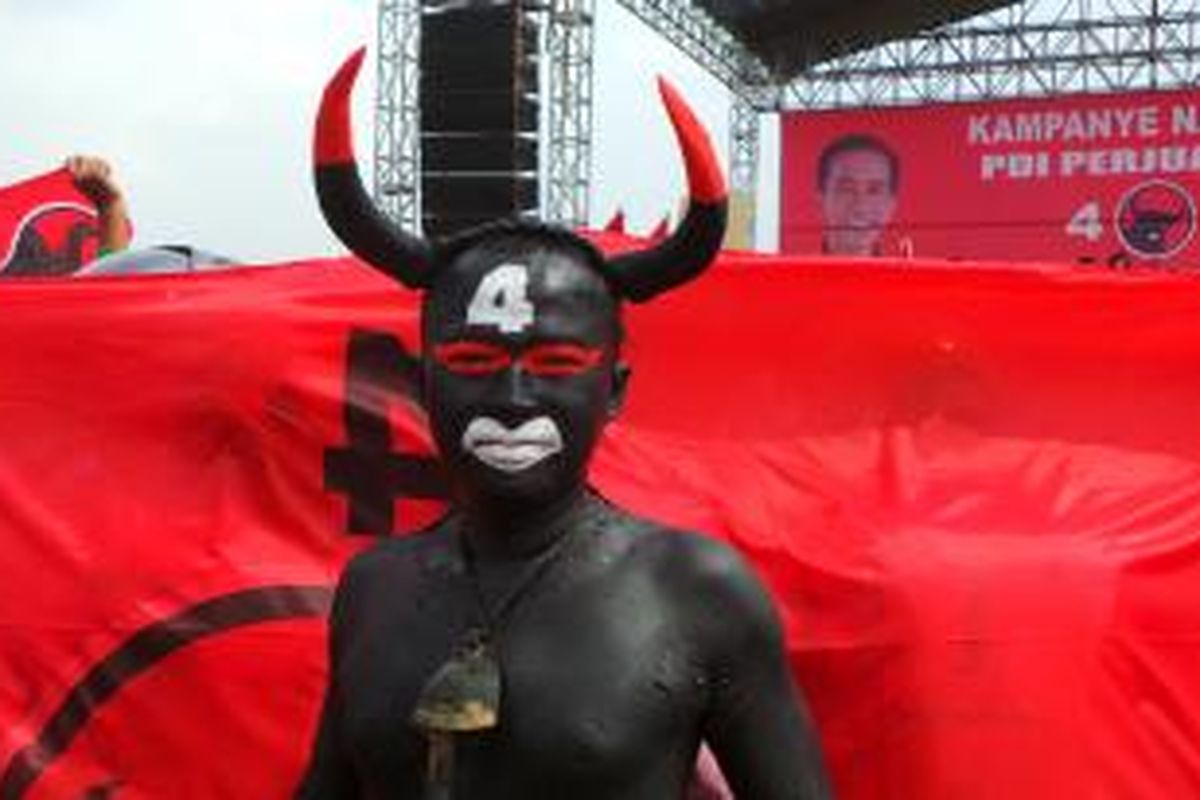 Seorang simpatisan PDI Perjuangan mencat tubuhnya menyerupai banteng, di Lapangan Thor, Surabaya, Jawa Timur, Senin (17/3/2014).