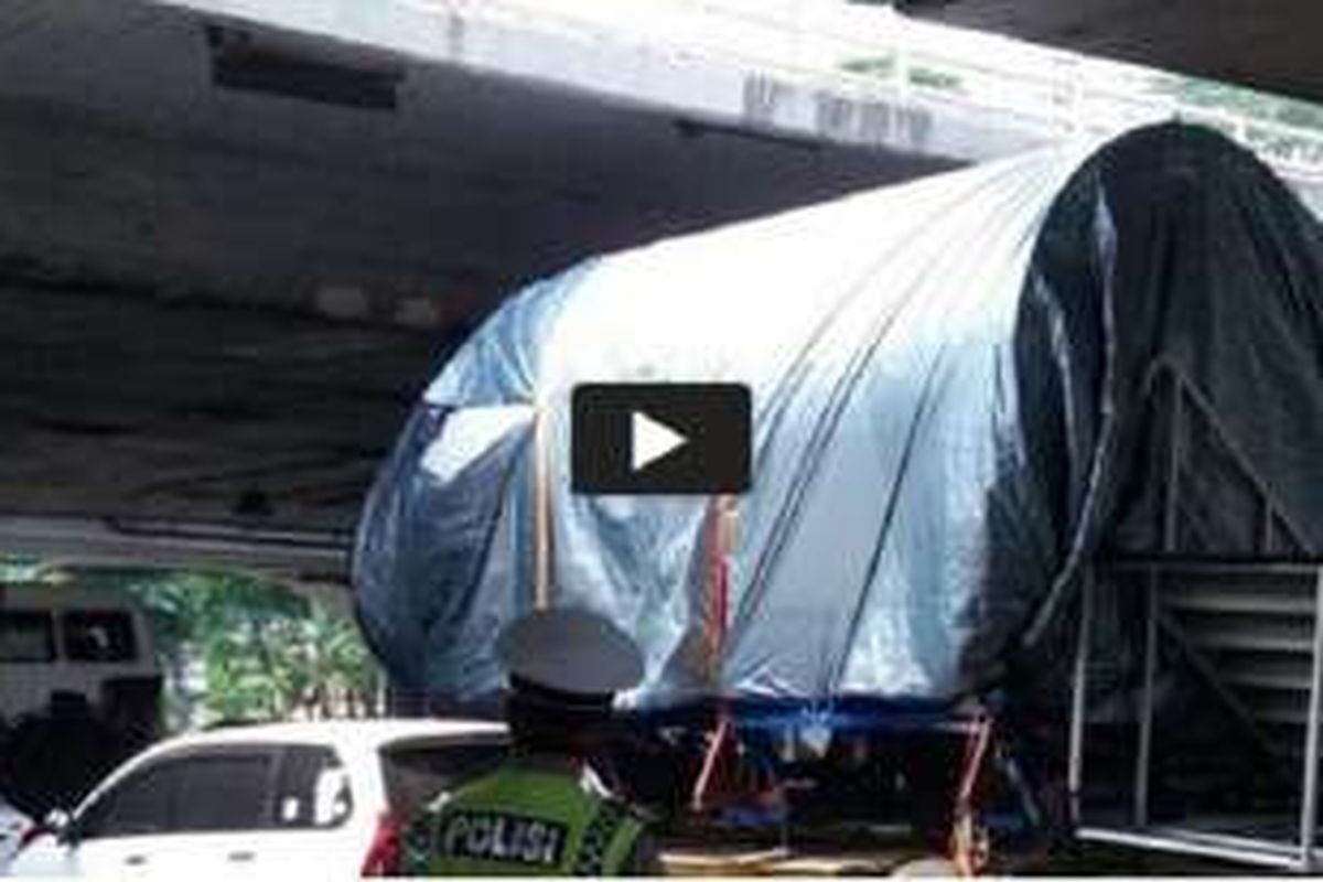 Truk pengangkut kepala pesawat tertahan saat hendak melewati kolong flyover Semanggi, Jakarta, Kamis (11/8/2016). Kepala pesawat bikinan BJ Habibie itu hendak dibawa ke Museum Nasional. 