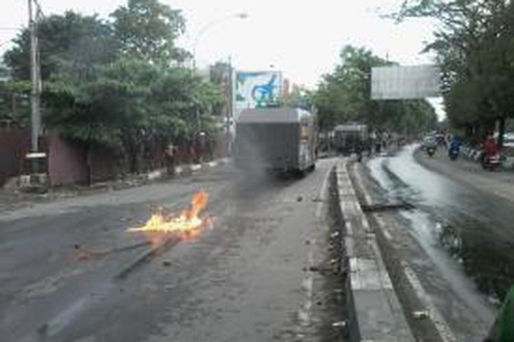Mobil water cannon dilempari bom molotov oleh mahasiswa saat melintas di samping gedung Phinisi, kampus Universitas Negeri Makassar,Rabu (19/11/2014) sore.