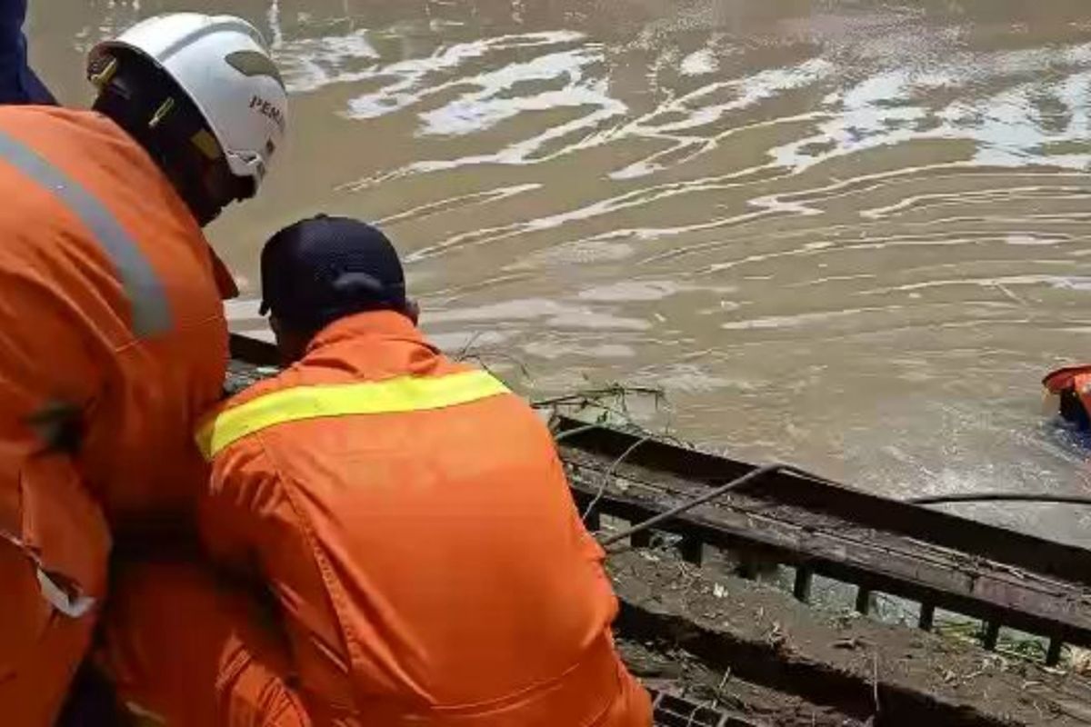 Petugas Sudin PKP saat evakuasi jenazah laki-laku tanpa identitas yang tersangkut di pintu air saluran Kalimalang, Duren Sawit, Jakarta Timur, Kamis (30/1/2020).