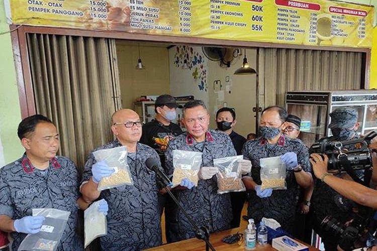 Deputi Pemberantasan BNN Irjen Pol Kenedy saat memegang barang bukti narkotika jenis ekstasi saat ekspos mengenai pabrik pembuatan narkotika jenis pil esktasi di Jalan Hangtuah, Pekanbaru, Rabu (26/10/2022).
