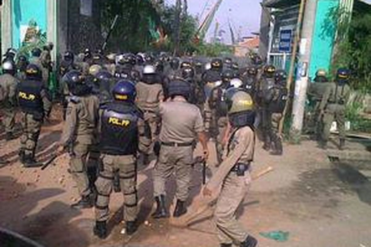 Aparat kemanan yang terdiri dari polisi dan satpol PP merangsek masuk ke dalam makam Mbah Priok, di Tanjung Priok, Jakarta Utara, Rabu (14/4/2010). Upaya Pemkot Jakarta Utara membongkar makam keramat itu ditentang ratusan warga.