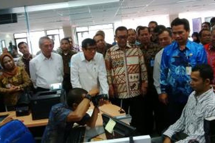 Menteri Hukum dan HAM Yasonna Laoly (tengah) dan Wakil Gubernur Jawa Barat Deddy Mizwar (dua dari kanan) saat sedang bercanda dengan pemohon paspor di gedung Unit Layanan Paspor kantor Imigrasi Kelas I Bandung di Bandung, Jawa Barat, Jumat (19/12/2014).