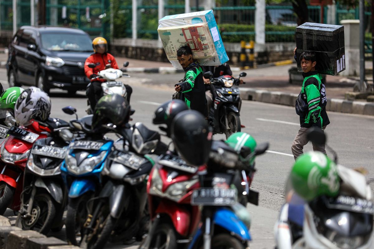 Pengemudi ojek online membawa barang-barang pesanan penumpang di Jalan Mangga Dua Raya, Jakarat Pusat, Rabu (11/3/2020). Kementerian Perhubungan (Kemenhub) resmi menaikan tarif ojek online untuk zona 2 atau wilayah Jabodetabek pada 16 Maret 2020. Kemenhub memutuskan untuk menaikan tarif batas bawah (TBB) ojol sebesar Rp 250 per kilometer (km) menjadi Rp 2.250 per km, dari sebelumnya Rp 2.000 per km.