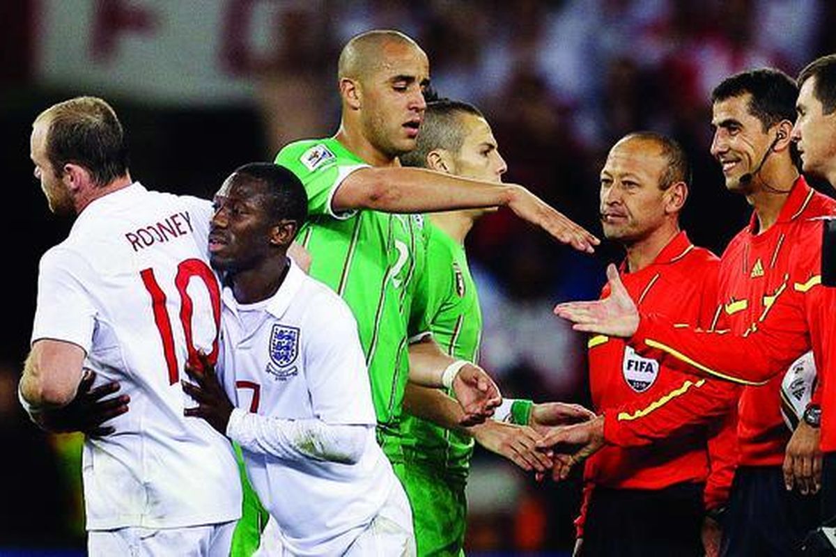 Pe m a i n Inggris, Shaun-Wright Phillips (kedua dari kiri), mendorong Wayne Rooney (kiri) menjauh saat wasit dan penjaga garis bersalaman dengan pemain Aljazair, Madjid Bougherra, pada laga Grup C di Cape Town, Afrika Selatan, Jumat (18/6). Rooney melancarkan protes keras kepada wasit pada akhir pertandingan. Inggris ditahan Aljazair 0-0