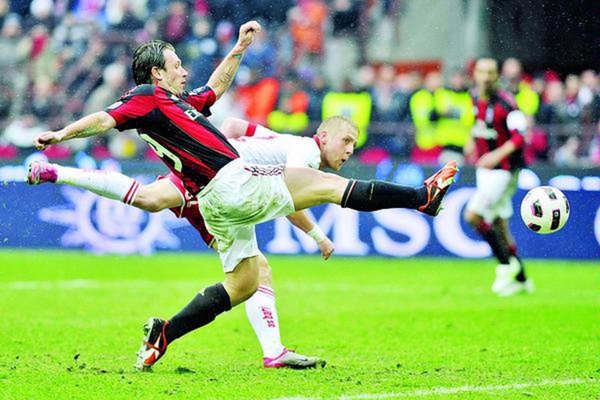 Striker AC Milan, Antonio Cassano (kiri), berusaha mengontrol bola di bawah penjagaan pemain belakang Bari, Kamil Glik, pada laga Serie A Italia di Stadion San Siro, Milan, Italia, Minggu (13/3). Bari menahan seri AC Milan, 1-1.