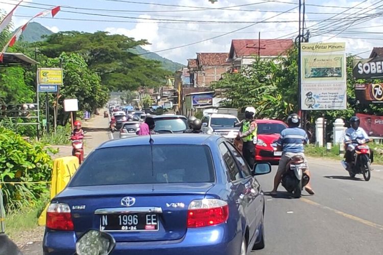 Anggota Satlantas Polres Trenggalek melakukan pengaturan arus lalu lintas, di tengah antrian kendaraan di Jalur utama Bendo Kecamatan Pogalan Trenggalek Jawa Timur, Senin (24/04/2023).