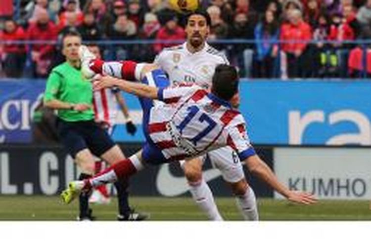 Gelandang Atletico Madrid, Saul Niguez (17), melakukan tendangan salto untuk mencetak gol ke gawang Real Madrid dalam laga Primera Division di Vicente Calderon, Madrid, Sabtu (7/2/2015).