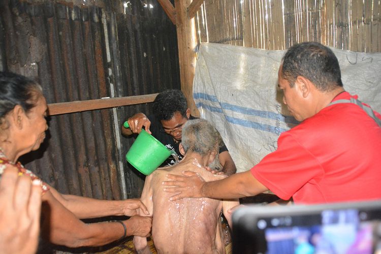 Pater Avent Saur SVD dibantu istri Stefanus Tauk serta seorang pekerja media sedang membersihkan tubuh pasien gangguan jiwa yang sudah sudah lumpuh, Sabtu (9/2/2019). 