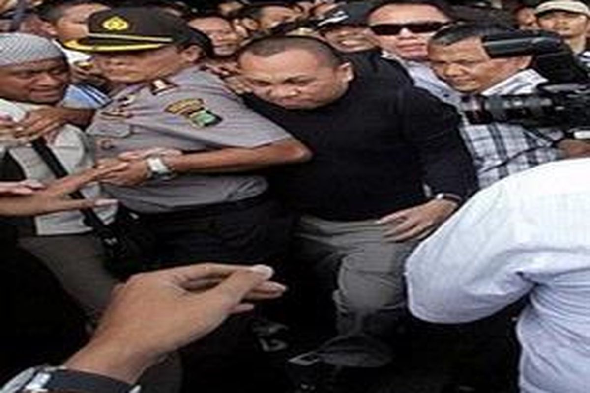 Indonesian tax official Gayus Tambunan is guarded by police at the Soekarno-Hatta airport in Tangerang. Pandemonium broke out at Jakartas international airport Wednesday as journalists and cameramen mobbed the young tax official who returned from Singapore for questioning over alleged corruption. 