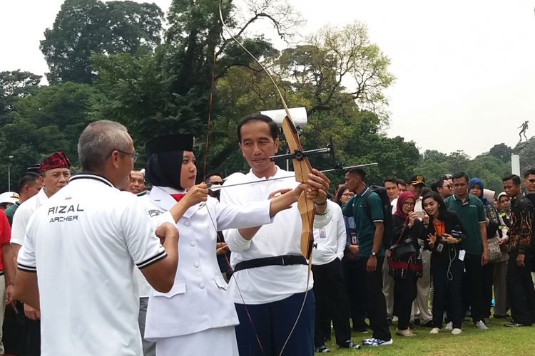 Presiden Joko Widodo mengajari anggota Paskibraka memanah di perayaan Sumpah Pemuda di Istana Bogor, Sabtu (28/10/2017).