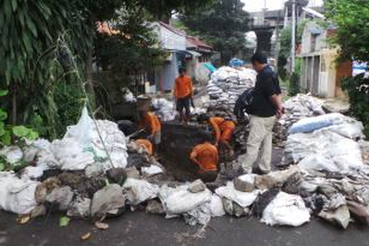 Jalan Cipinang Cimpedam IV jebol akibat bajir beberapa hari lalu. Jalan tersebut kini tengah dalam proses perbaikan. Selasa (17/6/2014).