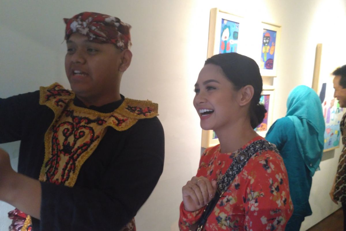 Penyanyi jazz Andien berfoto bersama Lutfi, salah satu pameris dalam Pameran Warna-Warna di Dia.Lo.Gue Art Space, Kemang, Jakarta Selatan, Selasa (28/8/2018).