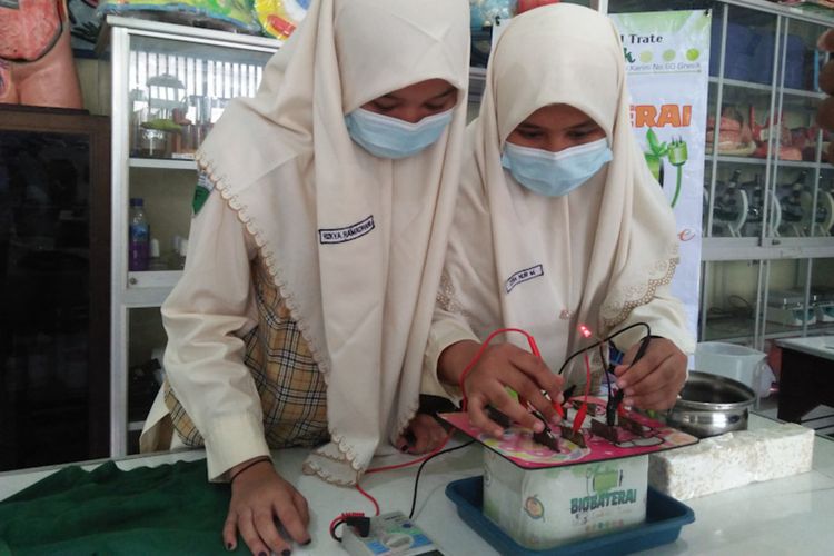 Citra Nur Ma'rifah (right) dan Rizkya Ramadhani and their science fair winning tempeh waste electricity project