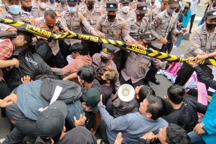 Sejumlah mahasiswa bersama petugas polisi yang berjaga terjatuh saat terlibat aksi saling dorong, di depan Gedung DPRD Kota Cirebon Jawa Barat pada Jumat (16/12/2022). Mahasiswa menolak beberapa pasal UU KUHP yang dinilai menciderai demokrasi Indonesia.