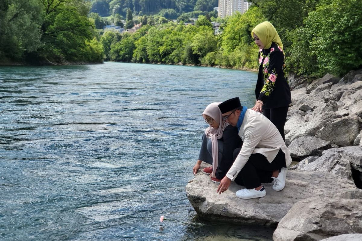 Gubernur Jawa Barat Ridwan Kamil beserta istri dan anak perempuannya menghanyutkan bunga mawar merah muda di Sungai Aaree, Bern, Swiss. 