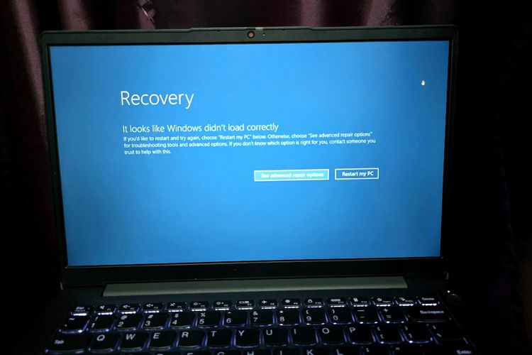 Laptop Windows  menampilkan latar belakang biru dan keterangan teks yang menunjukkan gangguan, sehingga meminta pengguna untuk restart. Tampilan itu juga disebut Blue Screen of Death (BSOD).
