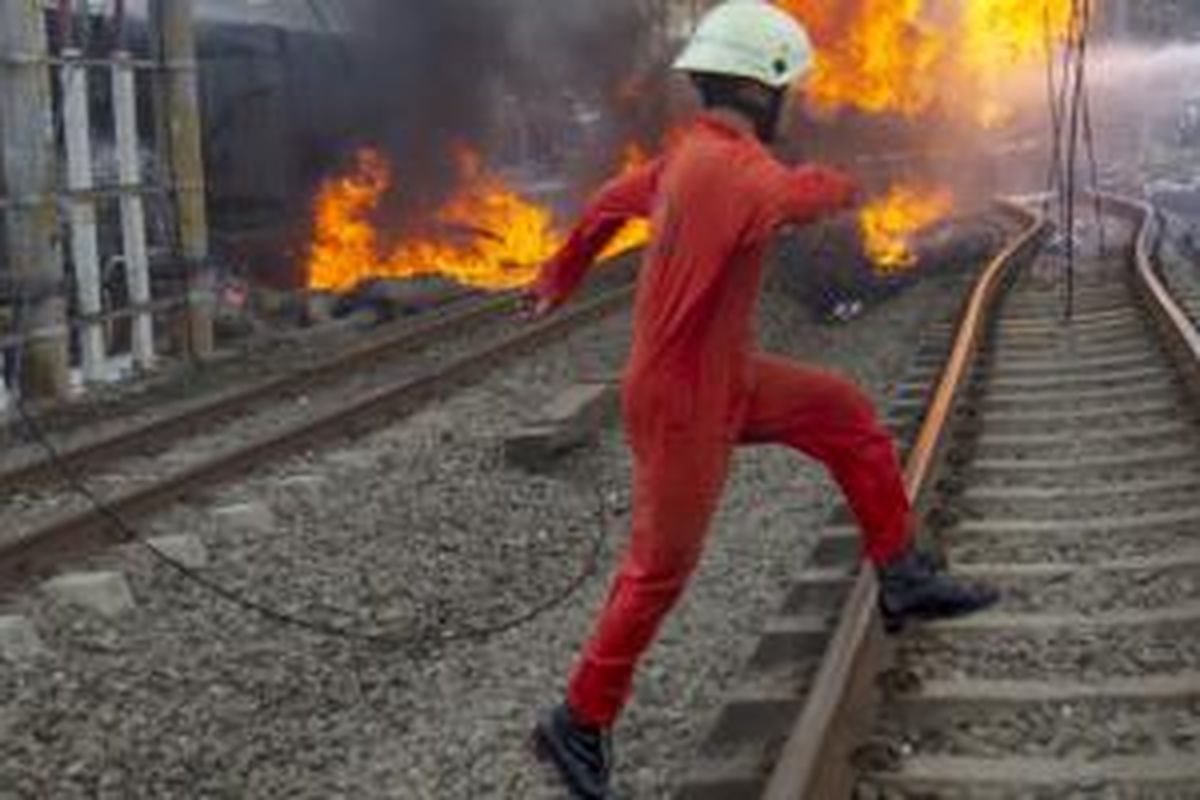 Suasana di lokasi tabrakan kereta rel listrik (KRL) jurusan Serpong-Tanah Abang dengan truk tangki pengangkut bahan bakar di pelintasan Pondok Betung, Bintaro, Jakarta Selatan, Senin (9/12/2013). Kecelakaan mengakibatkan sejumlah rangkaian gerbong dan truk tangki terbakar, menyebabkan seorang masinis dan seorang penumpang tewas, serta puluhan orang mengalami luka bakar. 