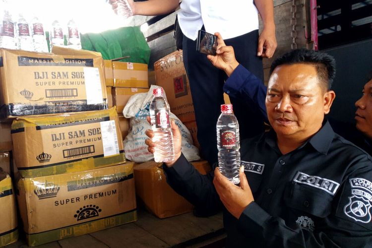 Kasi Humas Ipda Putut Siswahyudi menunjukkan minuman keras ilegal yang disita personel Satreskrim Polres Blitar, Selasa (10/9/2024)