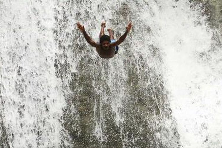 Bocah bermain di kawasan wisata Air Terjun Wafsarak, Kampung Amoi, Distrik Warsa, Kabupaten Biak Numfor, Papua, Senin (9/7/2012). Kawasan wisata alam yang ada di Biak Utara ini dapat ditempuh selama 1,5 jam perjalanan dari Kota Biak. Pengunjung ditarik Rp 25.000 per kendaraan. KOMPAS IMAGES/RODERICK ADRIAN MOZES