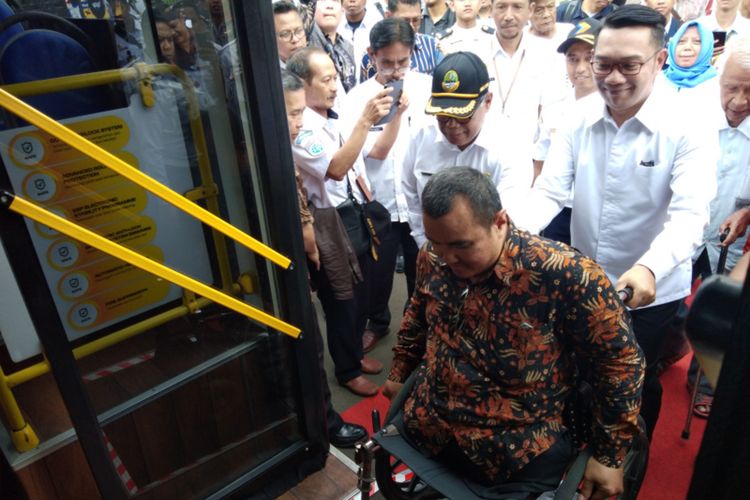 Gubernur Jawa Barat Ridwan Kamil saat membantu perwakilan masyarakat difabel dalam uji coba bus Scania di Monumen Perjuangan, Kota Bandung, Rabu (11/3/2020).