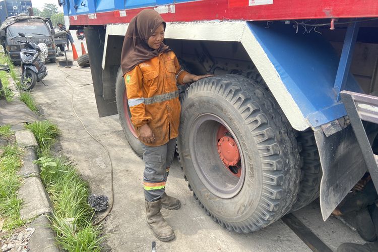 Siti Aisyah (35) perempuan di Surabaya yang berprofesi sebagai tambal ban truk, Minggu (30/11/2025)