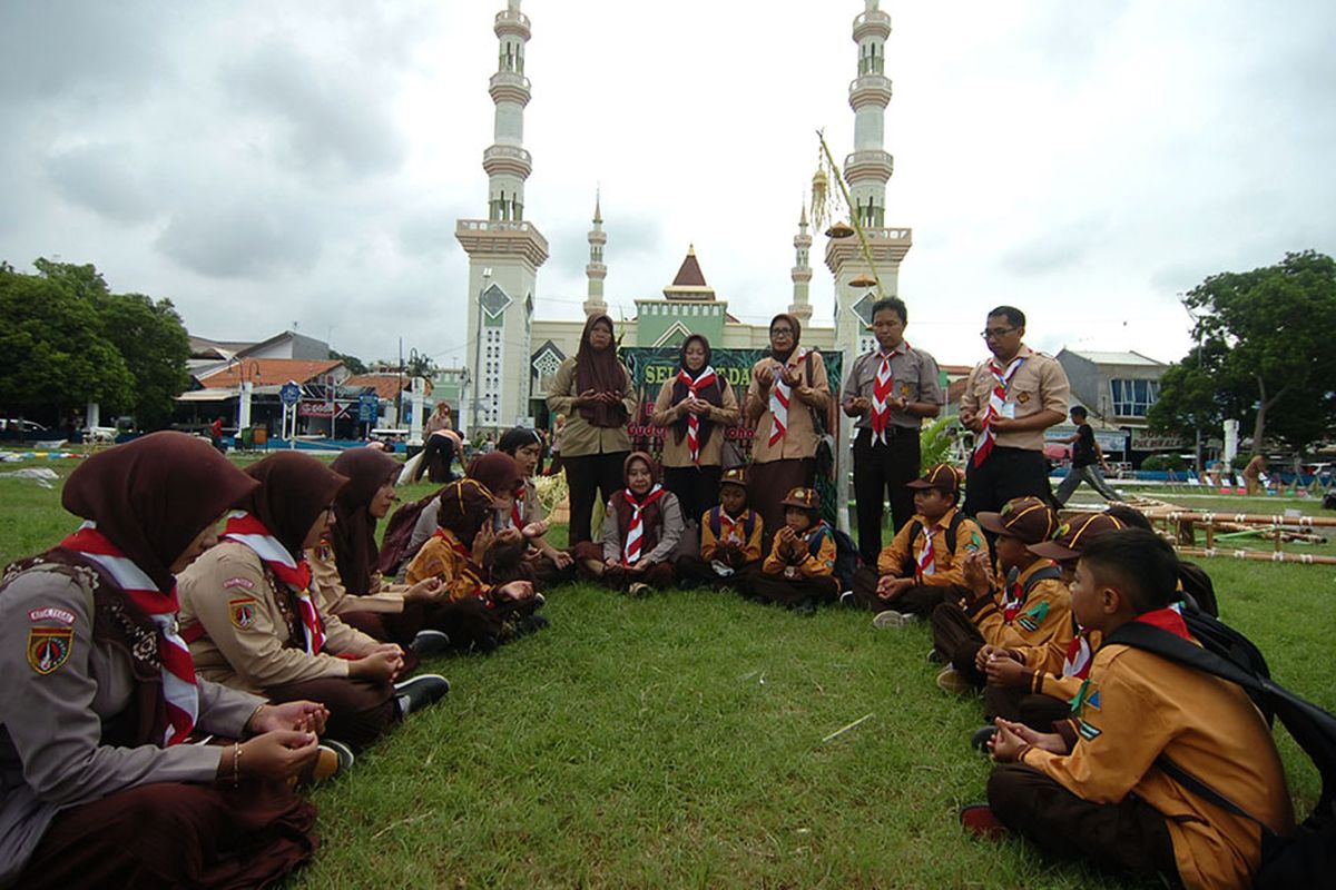 Sejumlah guru dan anggota pramuka melaksanakan doa bersama untuk korban susur sungai SMPN 1 Turi, Sleman di Alun-alun Tegal, Jawa Tengah, Sabtu (22/2/2020). Mereka mendoakan agar satu korban segera ditemukan dan sembilan korban yang meninggal memperoleh pengampunan Allah SWT.