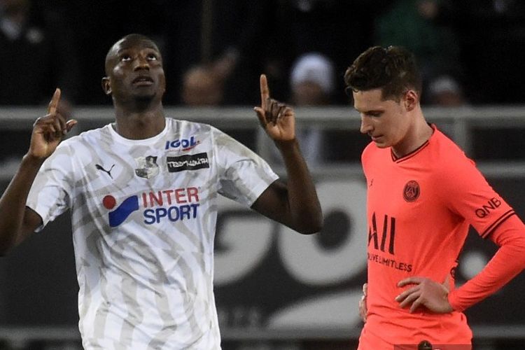 Pemain depan Amiens asal Kongo, Chadrac Akolo (kiri) merayakan setelah mencetak gol di sebelah gelandang Paris Saint-Germain Jerman Julian Draxler selama pertandingan sepak bola L1 Prancis antara Amiens SC dan Paris Saint-Germain (PSG) di stadion Licorne di Amiens, Perancis utara , pada 15 Februari 2020.