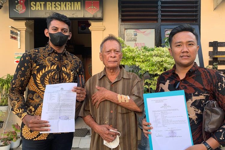 LAPOR—Kakek Anwar Wahyudi didampingi penasehat hukumnya, Wahyu Sesar Tri menunjukkan laporan penganiayaan yang menyebabkan tangannya luka dan berdarah karena dicakar WB tetangganya di Mapolres Madiun Kota, Kamis (4/8/2022).