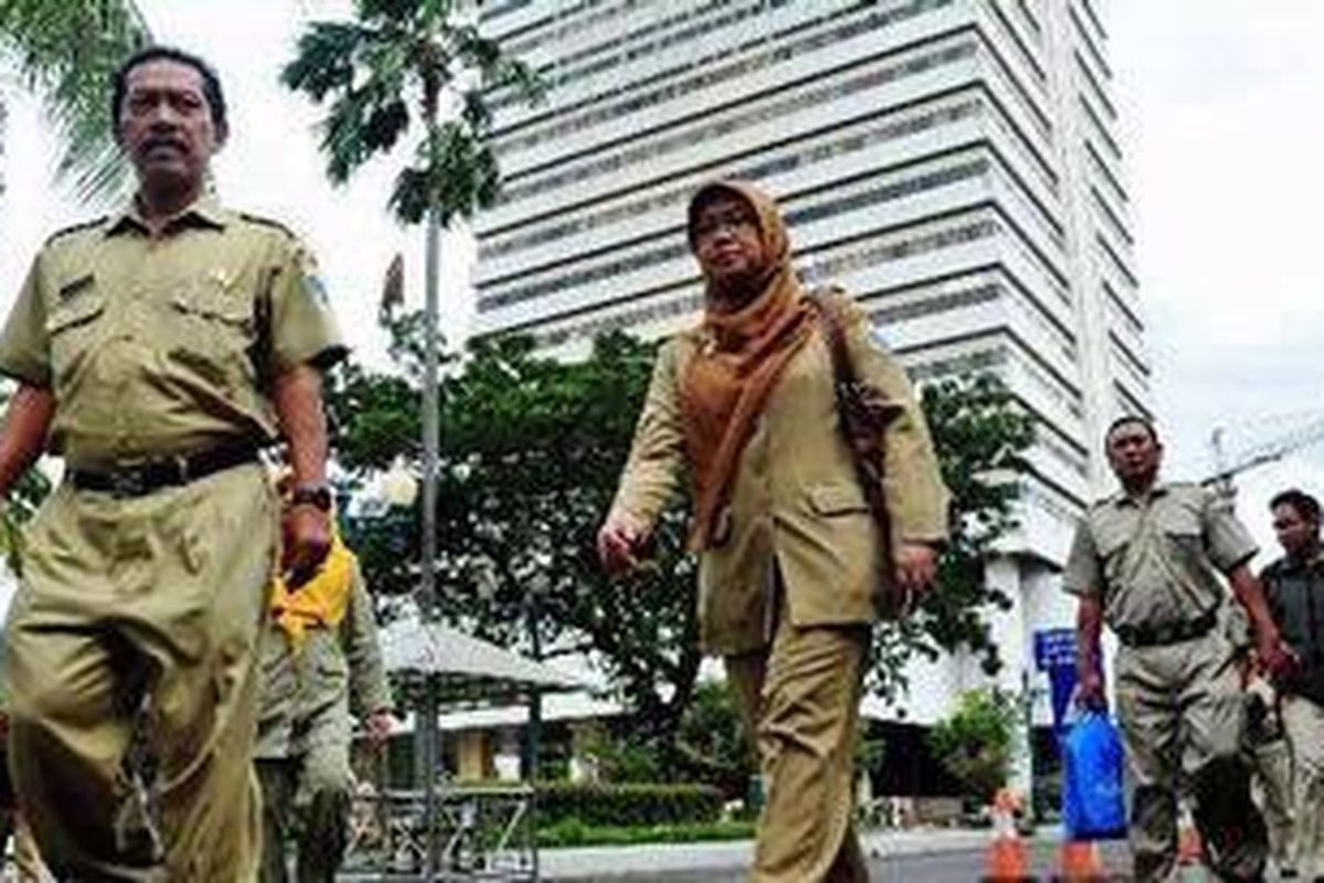 Sejumlah pegawai negeri sipil (PNS) melintas keluar dari gedung Balai Kota, Jakarta, Rabu (30/3/2011).