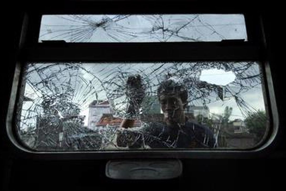 Pekerja mengganti kaca jendela yang pecah akibat kerusahan yang dilakukan Bonek, suporter Persebaya Surabaya di Staisun Jebres, Solo, Jawa Tengah, Selasa (26/1/2010).
