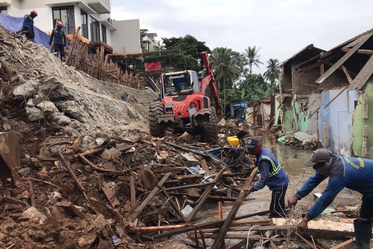 Petugas mengangkat material turap yang longsor di Jalan Damai 2 RT 04/RW 012, Ciganjur, Jagakarsa, Jakarta pada Senin (12/10/2020) sore.