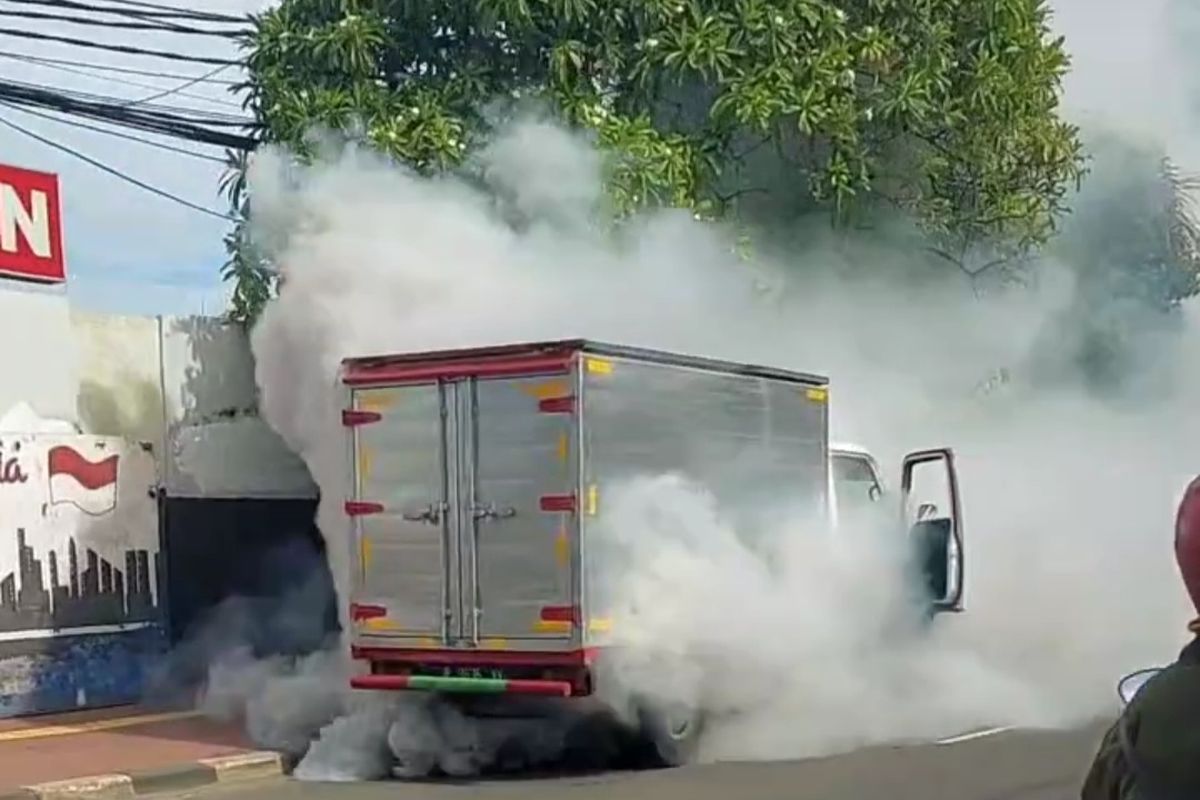 Sebuah mobil boks Isuzu ELF mengeluarkan asap putih tebal saat melintas di Jalan Prof. Dr. Latumenten Raya, Kelurahan Jelambar, Kecamatan Grogol Petamburan, Jakarta Barat, Jumat (25/11/2022).