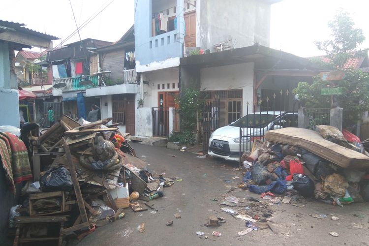 Warga Bidara Cina, Jakarta Timur, membersihkan rumah, Rabu (7/2/2018)