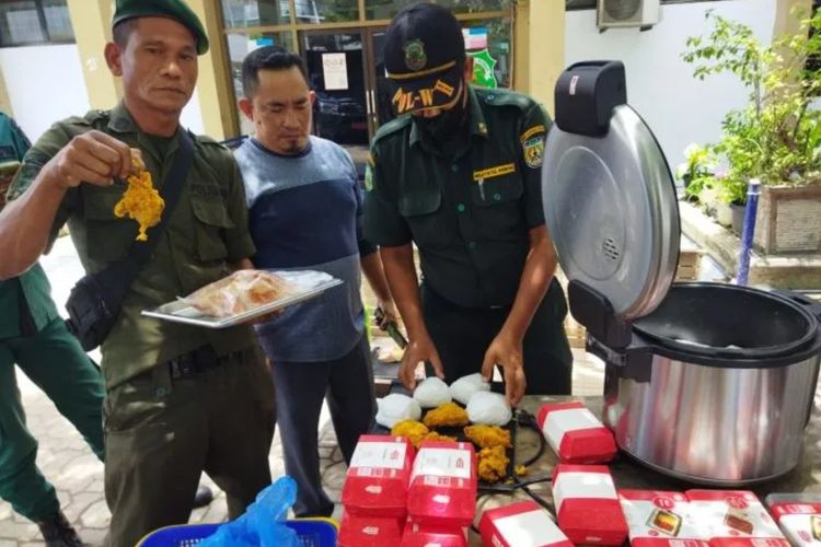 Petugas WH saat memperlihatkan bukti nasi dan ayam goreng yang diamankan dari salah satu minimarket di Banda Aceh karena menjual di siang hari, di Banda Aceh, Minggu (9/4/2023).