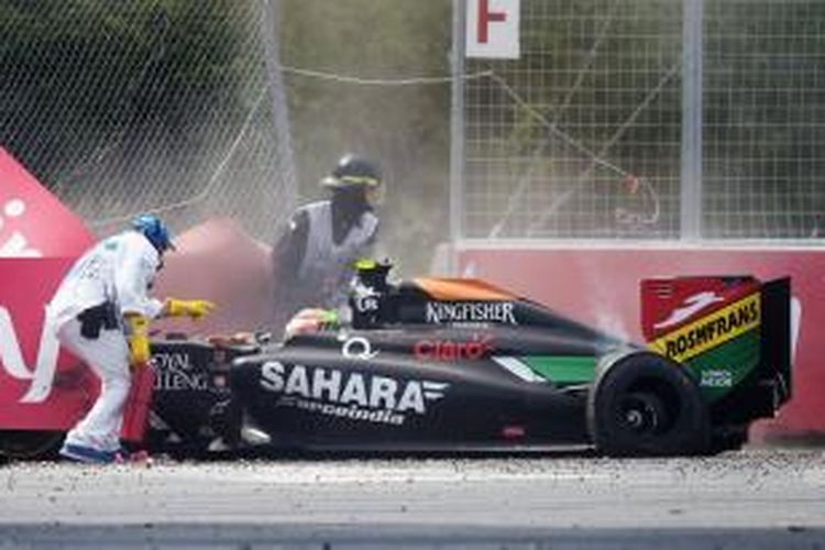 Para marshall tengah membantu pebalap Force India, Sergio Perez, setelah mobilnya menabrak pembatas pada GP Kanada, Minggu (8/6/2014).
