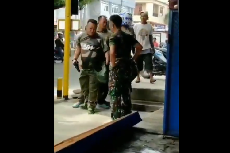 Tangkapan layar dari sebuah video yang memperlihatakan seorang prajurit tentara yang merebut pistol milik anggota polisi di Majene.