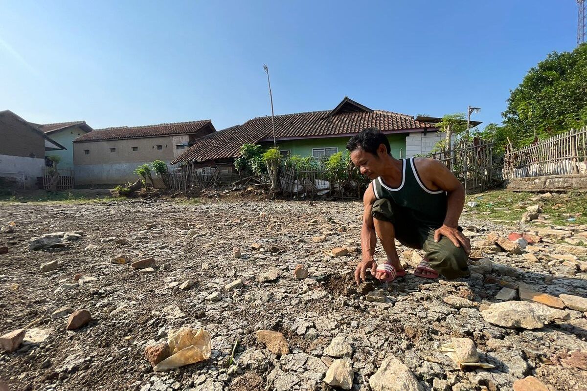 Ehor Rohman Ketua RT 03 RW 01 dan seorang warga Kampung Warung Cina, Desa Linggar, Kecamatan Rancaekek, Kabupaten Bandung, Jawa Barat tengah menunjukan kolam penampungan yang mengering pada Senin (21/8/2023)