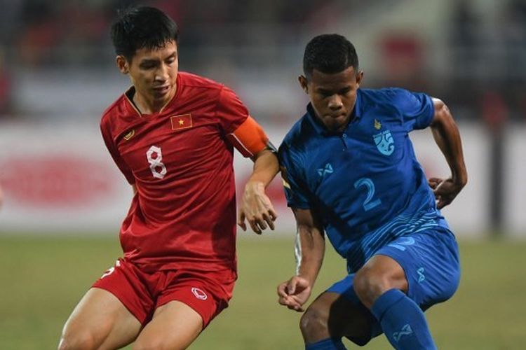 Kapten timnas Vietnam, Do Hung Dung, berebut bola dengan bek Thailand, Sasalak Haiprakhon, dalam final Piala AFF 2022 leg pertama, Vietnam vs Thailand, di Stadion My Dinh, Jumat (13/1/2023) malam WIB.