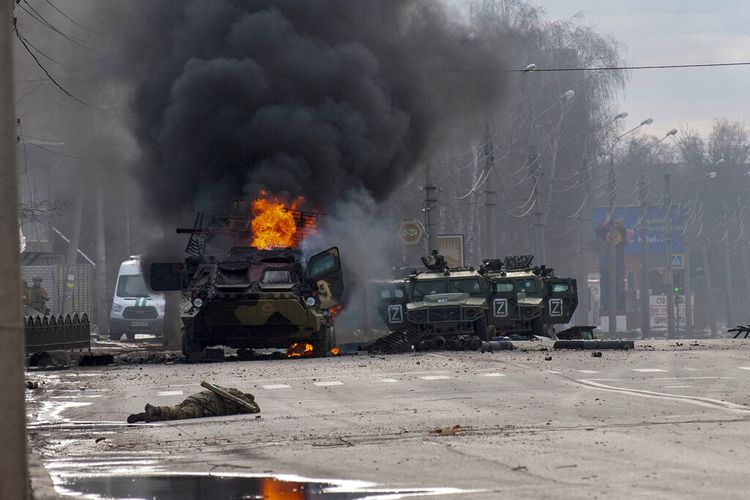 An armored personnel carrier burns and damaged light utility vehicles stand abandoned after fighting in Kharkiv, Ukraine, Sunday, Feb. 27, 2022. The city authorities said that Ukrainian forces engaged in fighting with Russian troops that entered the country's second-largest city on Sunday. 