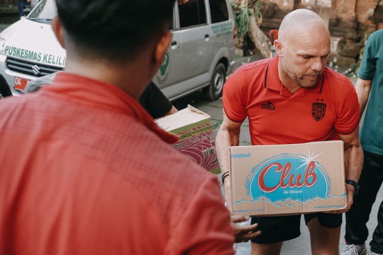 Pelatih Bali United Johnny Jansen saat aksi sosial memberikan bantuan kepada korban banjir di Posko Pengungsian Banjar Tohpati, Desa Kesiman Kertalangu, Denpasar Timur, Kamis (11/9/2025) sore.