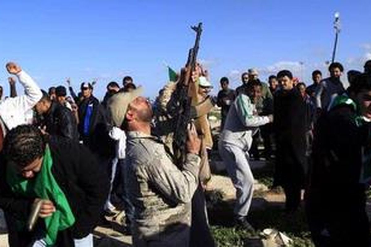 Tentara Libya menembakkan senjatanya ke udara saat pemakaman warga yang terbunuh akibat serbuan pasukan Barat di bawah kendali Amerika Serikat, di sebuah taman makam pahlawan di Tripoli, 20 Maret 2011. Liga Arab menyebut ini pemboman terhadap warga sipil. 