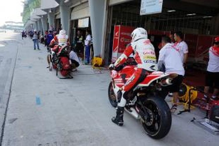 Pebalap Indonesia M Fadli dan Dimas Ekky saat memasuki pit di kualifikasi Asia Road Racing Championship, Sabtu (18/4/2015)