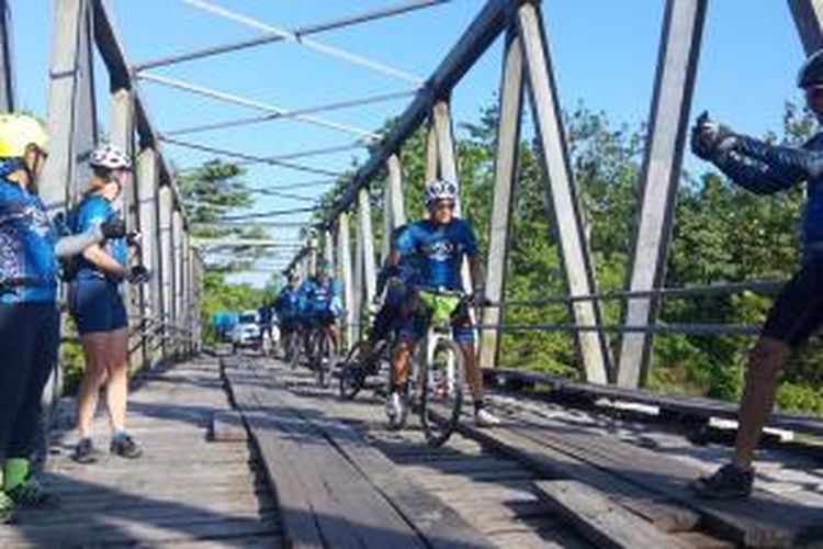 Peserta Jelajah Sepeda Papua berfoto-foto di jembatan dalam perjalanan menuju Sentani, Jayapura, Papua, Kamis (4/6/2015).

